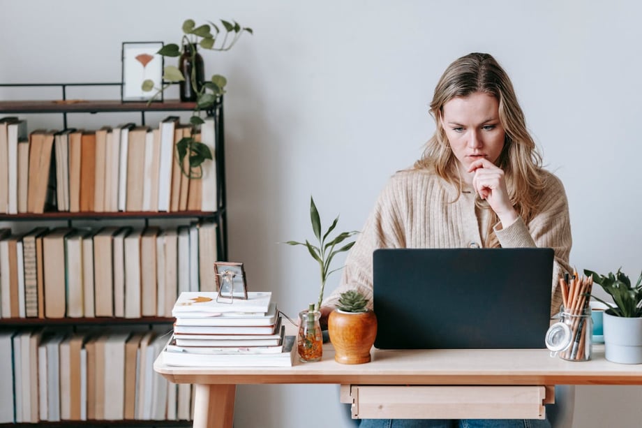 Woman writing meeting cancelation email on laptop